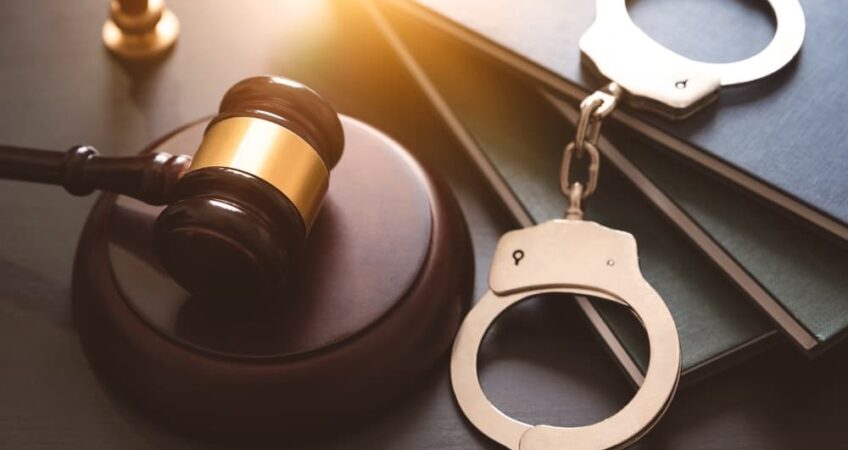 Handcuffs and wooden gavel.
